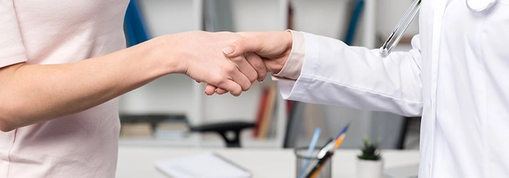Close-up of a healthcare professional and patient shaking hands